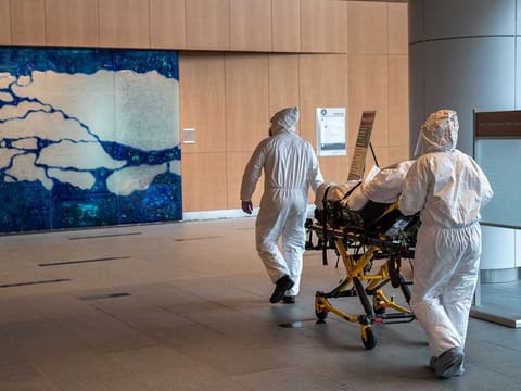 Medical staff wearing personal protective equipment (PPE) transport a COVID-19 patient at Stamford Hospital in Stamford, Connecticut (File)