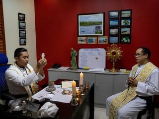 Hazmat suits and holy water: two priests bring faith to Philippines lockdown