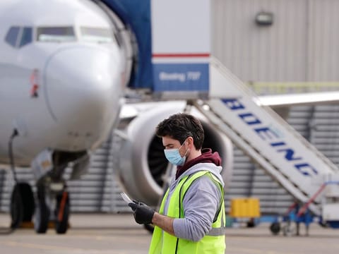 A worker walks past a Boeing 737 MAX jet at a Boeing airplane manufacturing plant Wednesday, April 29, 2020, in Renton, Washington. Recently Boeing to raised $25 billion from private investors and withdraw its request for a government rescue.