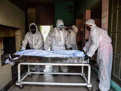 Personnel in protective suits, used due to the COVID-19 coronavirus outbreak, prepare to move a body inside the crematory chambers at a crematorium facility in Manila on April 29, 2020. 