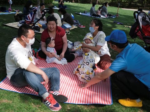 People talk while seating on picnic blankets at Sun Park during Labour Day holiday, following an outbreak of the coronavirus disease (COVID-19), in Beijing, China May 5, 2020. 