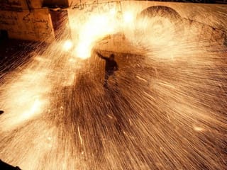 Palestinian youth swirl homemade sparkler firework in Gaza Strip