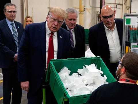 President Donald Trump and Tony Stallings, vice-president of integrated supply chain at Honeywell International Inc., right, listens to a worker during a tour of a Honeywell International plant that manufactures personal protective equipment, May 5, 2020, in Phoenix 
