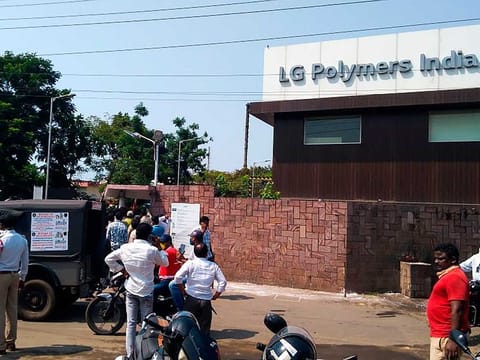 Policemen stand guard as people gather in front of an LG Polymers plant following a gas leak incident in Visakhapatnam on May 7, 2020. Gas had leaked out of two 5,000-tonne tanks that had been unattended due to India's coronavirus lockdown in place since late March. 