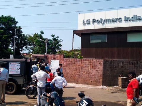 Policemen stand guard as people gather in front of an LG Polymers plant following a gas leak incident in Visakhapatnam on May 7, 2020. Gas had leaked out of two 5,000-tonne tanks that had been unattended due to India's coronavirus lockdown in place since late March. 