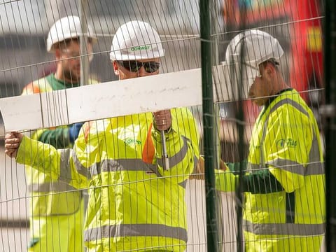 Construction workers erect fencing in London, UK, on Monday, in this file photo taken May 11, 2020. Six-month pilot programs for a four-day workweek with over 180 companies are currently underway in a half-dozen countries. Employers typically transition to four-day, 32-hour schedules (with variations depending on role and industry), with no reduction in pay. In the UK pilot, executives at companies with a total of 3,300 employees were surveyed at the halfway point. The program is operated in conjunction with the 4 Day Week Campaign and the think tank Autonomy, along with a data-collection partnership of researchers at Boston College, Cambridge University and Oxford University.