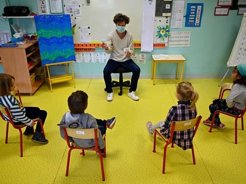 A teacher wearing a protective mask teaches children in her classroom (Image for illustrative uses only)