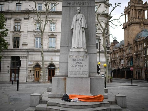 A homeless person sleeps on the plinth of the Edith Cavell Memorial near Charing Cross station in London on May 22, 2020 as lockdown restrictions to combat the spread of the novel coronavirus remain in place. 