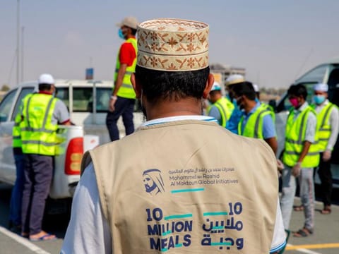 A meal distributor dons a 10 Million Meals gillet 