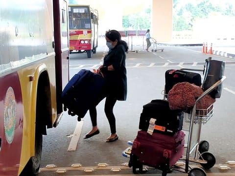 A woman board a bus after arriving at Cochin International Airport by a special flight from San Francisco, in Kochi on Monday. 