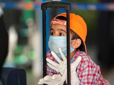 A child wearing a protection mask and gloves is seen at Indira Gandhi International (IGI) airport, after the government allowed domestic flight services to resume, during an extended nationwide lockdown to slow the spread of the coronavirus disease (COVID-19), in New Delhi, India, on May 25, 2020. 