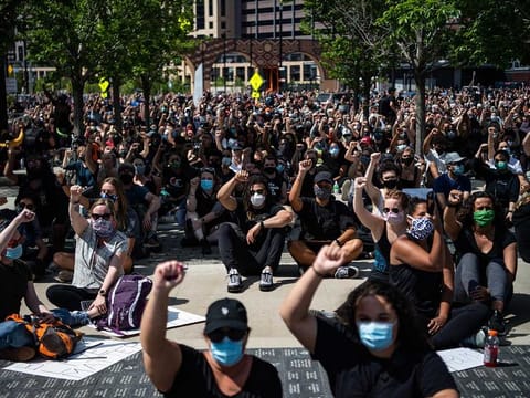  People raise their hands during a protest in Minneapolis.
