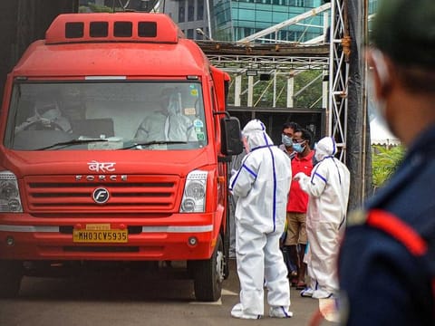 Medical staff wearing personal protective equipment (PPE) oversee COVID-19 patients boarding an ambulance as they are shifted from a field hospital to another facility ahead of a cyclonic storm that may hit the North Maharashtra and Gujarat coast, in Mumbai on June 2, 2020. 