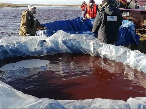 This handout photograph released by the Marine Rescue Service of Russia on June 4, 2020, shows rescuers as they pump out pollutions of a large diesel spill in the Ambarnaya River outside Norilsk. 