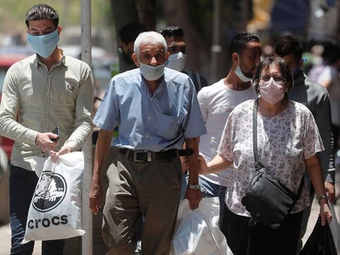 People wearing face masks  to prevent the spread of the  coronavirus disease (COVID-19) walk in Cairo.
