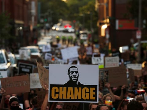 A demonstrator holds a sign with an image of George Floyd and the word "Change" during a rally against the death in Minneapolis police custody of Floyd, in Boston, Massachusetts, US, June 4, 2020. 