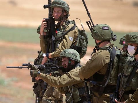 A member of the Israeli security forces fires towards Palestinian demonstrators during a protest against Israel's plan to annex parts of the occupied West Bank, near the village of Atuf in the Jordan Valley on June 5, 2020