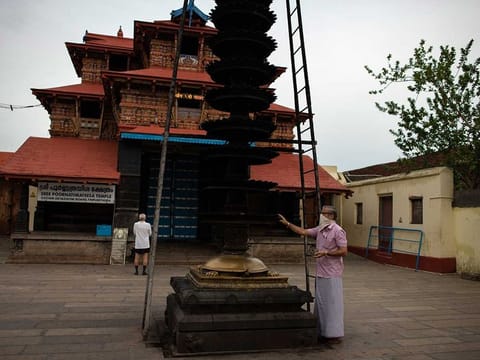 Devotees worship from outside a Hindu temple that remained closed to devotees due to the COVID-19 pandemic in Kochi, Kerala state, India, on Monday, June 8, 2020. 