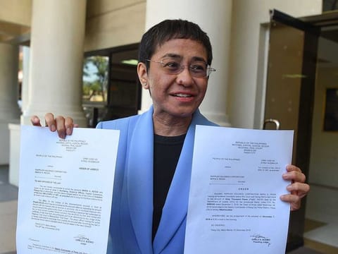 Maria Ressa, CEO and executive editor of online portal Rappler, showing the warrant of arrest order after posting bail at a court in Manila. File photo