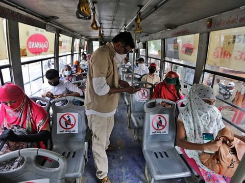 Passengers on a city bus in Ahmedabad, India, Wednesday, June 10, 2020. India's coronavirus cases are spiking amid government reopening restaurants, shopping malls and religious places in most of its states after a more than 2-month-old lockdown. 