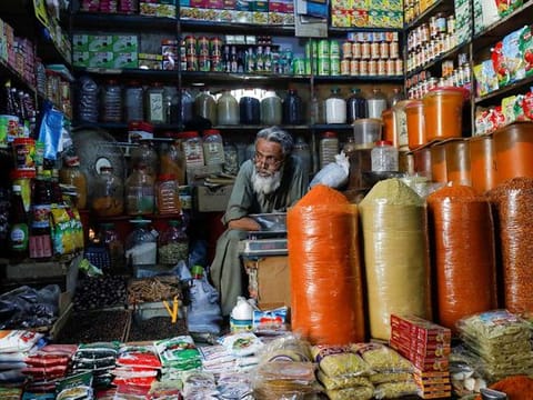 A shopkeeper waits for customers while selling spices and groceries items at a traditional retail market in Karachi, Pakistan 