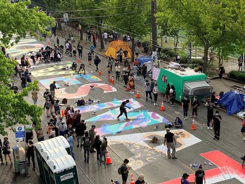 People create a Black Lives Matter mural on a street of Seattle, Washington, US