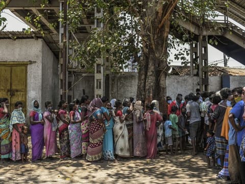 Migrant workers, many of whom are women, stuck in Mumbai, India, during the coronavirus lockdown line up for food in the sprawling slum of Dharavi on Monday, April 27. India’s women were already dropping out of the labour force.  