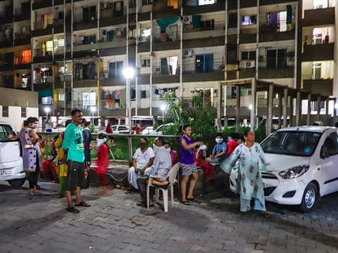 People move out of their apartments and compounds to an open area following an earthquake, in Ahmedabad, on June 14, 2020. 