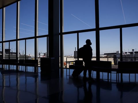 A passenger wearing a protective mask walks through the American Airlines Group Inc. area at O'Hare International Airport (ORD) in Chicago, Illinois, U.S., on Saturday, June 13, 2020. 