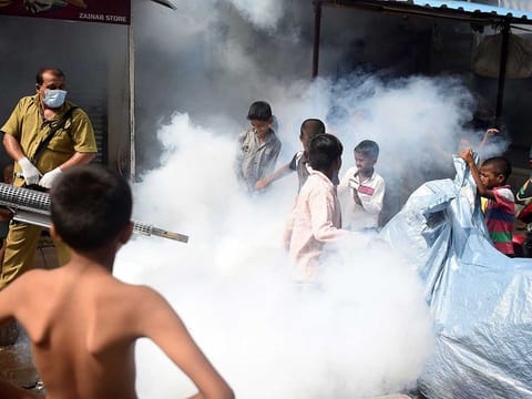 In this picture taken on June 12, 2020, a civic authority worker (L) fumigates a slum area to kill disease-carrying mosquitoes in Mumbai ahead of the monsoon season. With hospitals already severely stretched, COVID-19-hit India is now bracing for the monsoon and its deadly annual onslaught of mosquito-borne illnesses, with an overwhelmed army of public health workers the only defence. 