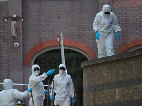 Police forensic officers search near the scene of a fatal multiple stabbing attack in Forbury Gardens, central Reading, England, Monday June 22, 2020. 