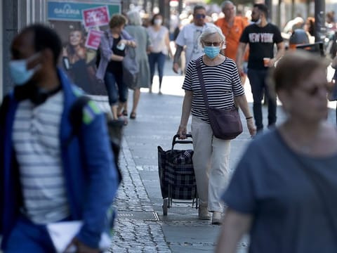 People with face masks walk on a shopping road in Berlin, Germany.