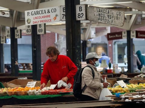 A customer wearing a protective face mask walks through the outdoor market in Leicester, U.K., on Monday, June 29, 2020. 