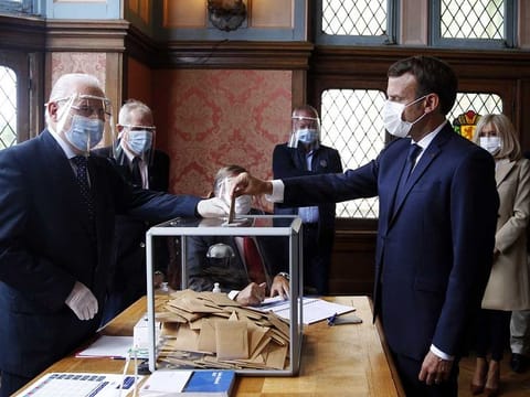 French President Emmanuel Macron casts his ballot for the second round of the mayoral elections at a polling station in Le Touquet, nothern France, on June 28, 2020. 