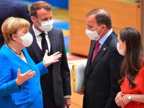 German Chancellor Angela Merkel (left) and French President Emmanuel Macron (second left) speak with Sweden's Prime Minister Stefan Lofven (second right) and Finland's Prime Minister Sanna Marin during a round table meeting at an EU summit in Brussels on July 18, 2020. Leaders from 27 European Union nations meet face-to-face for a second day of an EU summit to assess an overall budget and recovery package spread over seven years estimated at some 1.75 trillion to 1.85 trillion euros. 