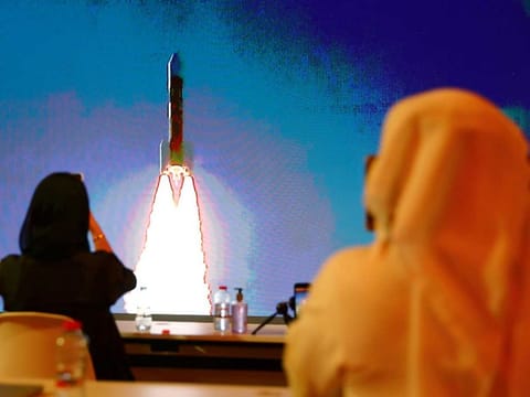 People watch a big screen displaying the launch of the Hope Probe from Tanegashima Island in Japan, at the Mohammed bin Rashid Space Centre in Dubai.