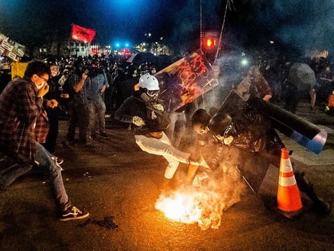 Black Lives Matter protesters try to move a projectile launched by federal officers at the Mark O. Hatfield United States Courthouse on July 24, 2020, in Portland, Oregon, US. 