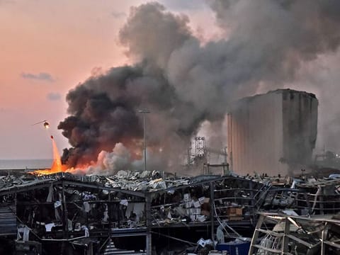 A helicopter puts out a fire at the scene of an explosion at the port of Lebanon's capital Beirut.