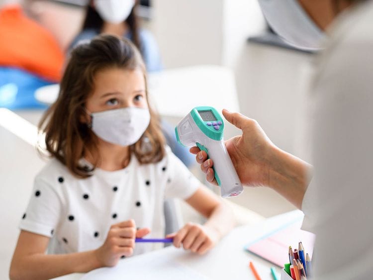 What happens if a child gets COVID-19 symptoms at school?