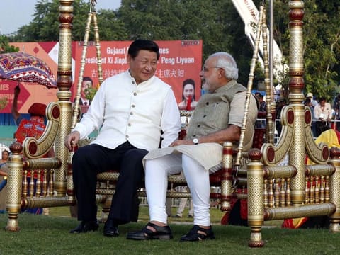 Chinese President Xi Jinping sits on a swing with Indian Prime Minister Narendra Modi at a riverside park in Gujarat in 2014