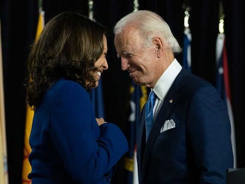Democratic presidential candidate former US vice-president Joe Biden and his running mate Senator Kamala Harris pass each other during a campaign event in Wilmington, Delaware, on August 12, 2020.