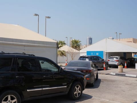 Motorists wait at a drive-through centre for COVID-19 at the Bahrain International Exhibition and Convention Centre in a file picture..