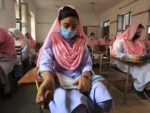 Students wear protective masks maintaining safe distance as they attend a class, after government allowed reopening of schools from grade six to eight amid the coronavirus disease (COVID-19) pandemic, in Peshawar, Pakistan September 23, 2020. 