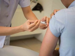 Who can get the flu vaccine for free in the UAE and where can you get it?