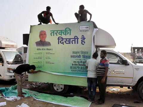 Workers prepare a Janata Dal (United) vehicle for the campaign ahead of the upcoming Bihar Assembly Election in Patna on Tuesday.