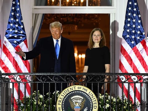 US President Donald Trump gestures next to Judge Amy Coney Barrett after she was sworn in as a US Supreme Court Associate Justice during a ceremony on the South Lawn of the White House October 26, 2020, in Washington, DC.