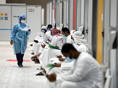 People sit as they wait their turn for vaccine trials at Abu Dhabi National Exhibition Center in Abu Dhabi, United Arab Emirates.Reuters