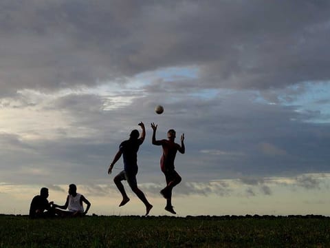 In this April 10, 2019, file photo, young men play a game of rugby at sunset in Nuku'alofa, Tonga. The largest cluster of places without the coronavirus can be found in the scattered islands of the South Pacific. Tonga, Kiribati, Samoa, Micronesia and Tuvalu are among those small nations yet to report a single case. 