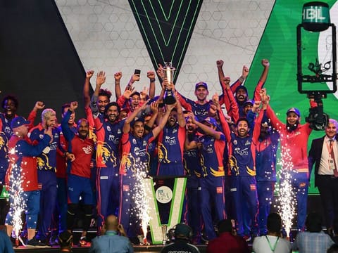 Karachi Kings team members and support staff celebrate with the PSL winners' trophy in Karachi on Tuesday evening. 