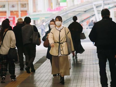  People wearing face masks to help curb the spread of the coronavirus walk at an underpass in Tokyo.
